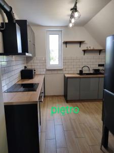 a large kitchen with a counter and a window at Apartamenty całoroczne Ślesin in Ślesin +3 photos