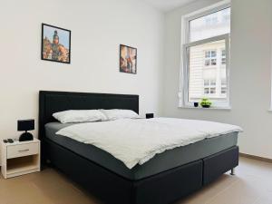 a bedroom with a large bed and a window at Hollywood Apartment XXL in Bremerhaven