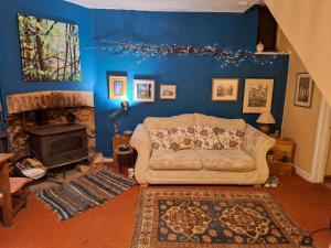 a living room with a couch and a fireplace at 2 White Horse Cottages in Washford