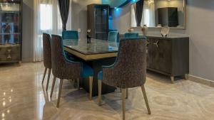a dining room with a glass table and chairs at El Obour Home - العبور in Obour