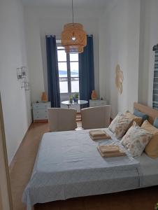 a bedroom with a bed with chairs and a table at Aegina Port Apt 4 in Egina