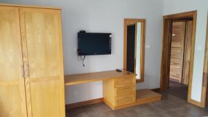 a room with a desk with a television on a wall at Residenceticoco in Grand Baie