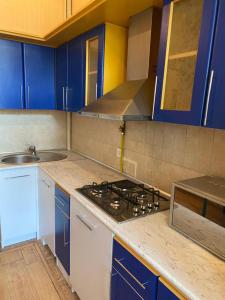 cocina con armarios azules y fogones en Квартира в сердце Баку, en Baku 7 fotos más