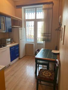 Una pequeña cocina con una mesa y un refrigerador. en Квартира в сердце Баку, en Baku