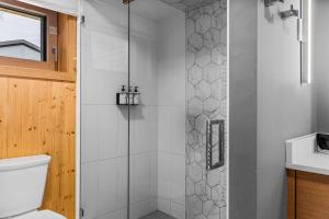a shower with a glass door in a bathroom at Alps #201- LEED Gold Certified & Dog Friendly in Canmore