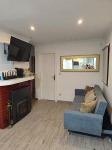 un salon avec un canapé bleu et une cheminée dans l'établissement Casa Pejão Do Paraíso, à Castelo de Paiva