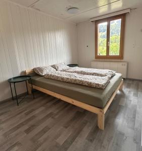 a bedroom with a bed in a room with a window at Grosses Chalet im Grünen in Oberwil +4 photos