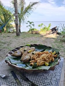a plate of food on a table near the beach at Filhas da Terra Jaguanum in Itacuruçá +53 photos