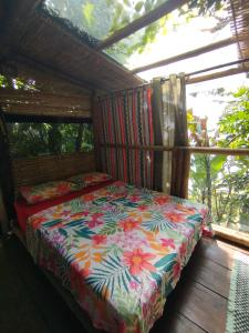a bedroom with a bed with a colorful comforter at Filhas da Terra Jaguanum in Itacuruçá