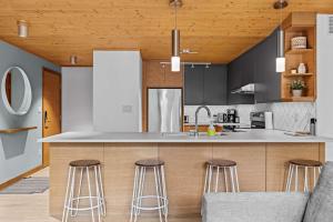 a kitchen with a counter and stools in it at Pyrenees #202 - LEED Gold Certified in Canmore