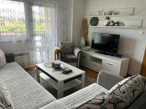 a living room with a couch and a tv at Cozy corner Mostar in Mostar