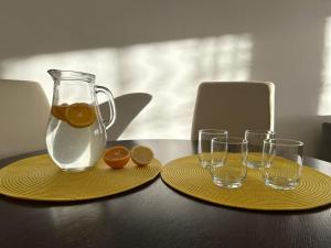 two yellow plates with a pitcher and glasses on a table at Cozy corner Mostar in Mostar