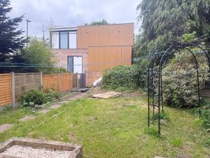 a garden with a gate in front of a house at D'Luxe Royal 3 bedrooms house in Abbeywood, London in Belvedere