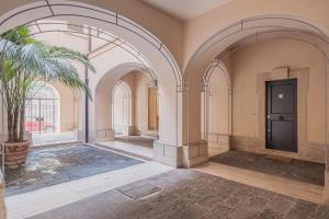 an empty room with a door and a palm tree at Elegant apartment inside the Roman Forum in Rome