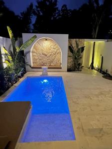 a swimming pool in front of a house at night at NEW CASA ULU - 10Min to white beaches in Uluwatu +23 photos