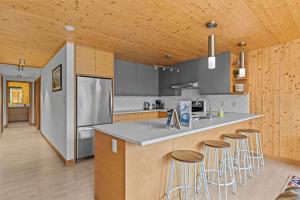 a kitchen with a counter with stools in it at Dolomites #203 - LEED Gold Certified in Canmore +61 photos