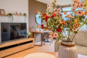 un vase avec des fleurs sur une table dans un salon dans l'établissement Sauna und Wandern im Bayernwald, à Regen