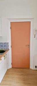 an orange door in a kitchen with a wooden floor at Studio centre Rennes in Rennes +1 photo