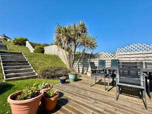 a deck with a table and chairs and some plants at The Rise-5 Bed-4 Bath-Family-Beach-Home in Trearddur