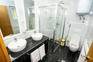 a bathroom with two sinks and a shower and a toilet at Villa Hills Sarajevo in Sarajevo +12 photos