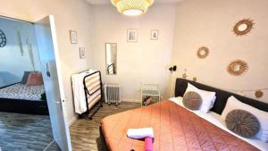 Charme de Blois à 2 min Château Local à vélos في بلوا: غرفة نوم مع سرير مع لحاف برتقالي