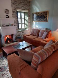 a living room with a couch and a fireplace at Villa Exohi Rooftop in Exochí