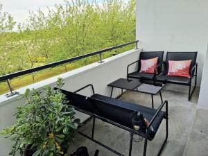 圣雅克德拉朗德Le Cocon Botanique Rennais的阳台上配有两把黑色椅子,享有美景