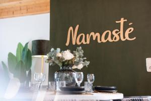 a table with a vase of flowers and a sign that reads menace at NAMASTÉ Homes - Ferienwohnung mit Balkon & Carport in Bad Windsheim