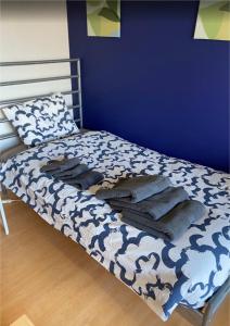a bed in a room with a blue wall at 下町の穴場 キッチン完備 長期滞在に最適なお部屋 Rapyuta monthly apartment in Kyoto