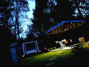 a tent with lights in a yard at night at Domek na grapie in Gilowice