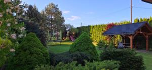 a group of trees in a yard with a gazebo at Pod Jednym Dachem in Skawa