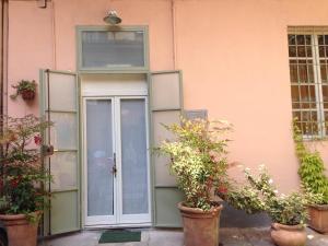 トリノにあるCasadama Guest Apartmentの鉢植えのピンクの建物への扉