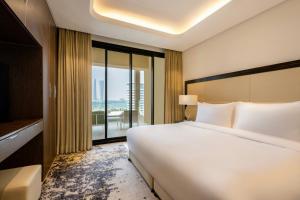 Een bed of bedden in een kamer bij Agora, Doha, Autograph Collection