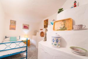 Una habitación con paredes blancas y una cama y estantes. en Casa Daniela, Vista Mare Sea View, en Chia