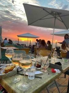 un tavolo con bicchieri da vino e vista sull'oceano di Appartement terrasse Malo à 2 pas de la plage a Dunkerque