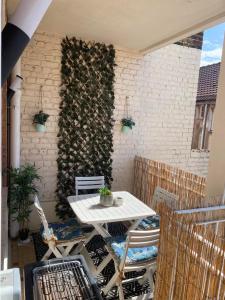 un tavolo bianco e sedie su un patio con un muro di mattoni di Appartement terrasse Malo à 2 pas de la plage a Dunkerque