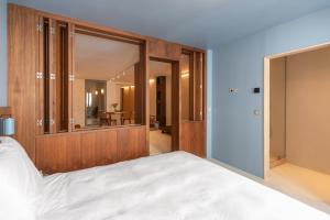 a bedroom with a large white bed and a mirror at Suite d'exception Marais in Paris +12 photos