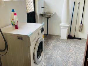 a laundry room with a washing machine and a sink at Kanapathiy Rest House in Trincomalee +14 photos