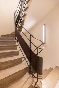 a staircase with a black rail and wooden steps at Suite d'exception Marais in Paris