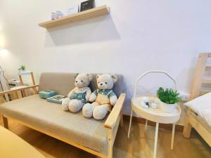 two teddy bears are sitting on a couch at Secret Muji Vintage Building ห้องลับมูจิในตึกวินเทจ in Ban Song Hong