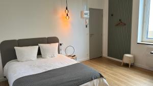 a bedroom with a bed with white sheets and a window at Studio moderne/rue Encombe Vineuse- DABNB in Limoges