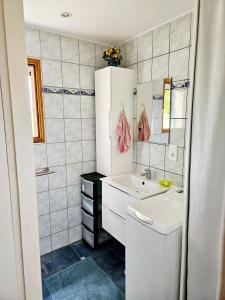 un bagno bianco con lavandino e specchio di Le Bastidon de Dudule a Montagnac