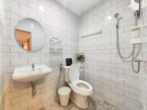 a bathroom with a toilet and a sink and a mirror at Secret Muji Vintage Building ห้องลับมูจิในตึกวินเทจ in Ban Song Hong