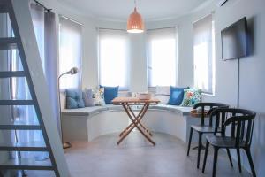 a living room with a table and chairs and a couch at Camara Homes in Andros