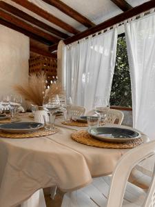 a white table with glasses and plates on it at Villa Rossella in Campu Longu +15 photos