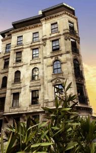 a large stone building with windows and a tree at GALATA M84 in Istanbul