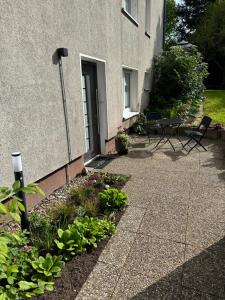a patio with a table and chairs next to a building at Ferienwohnung am Waldesrand in Blomberg +3 photos