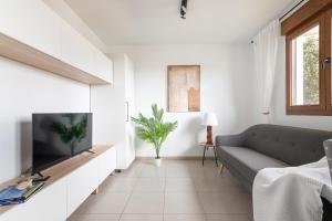 a living room with a couch and a flat screen tv at Duplex cerca de la playa con piscina in Miengo