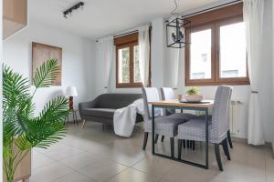 a living room with a table and chairs and a couch at Duplex cerca de la playa con piscina in Miengo