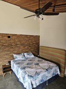 een slaapkamer met een bed met een plafondventilator bij Chalé Curvas da Canastra in São Roque de Minas +22 foto's